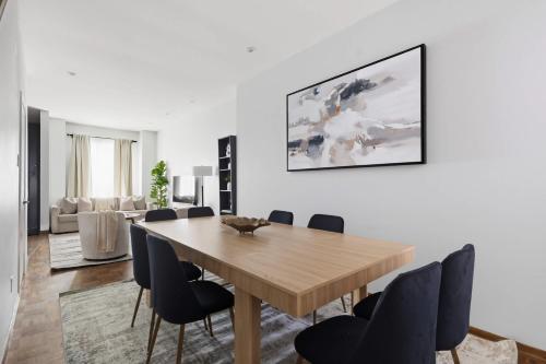 a dining room with a wooden table and chairs at Stylish 4BR Toronto House Backyard Dinners in Toronto