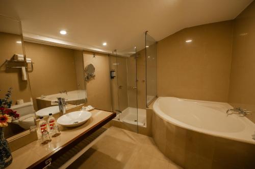 a bathroom with a tub and a sink and a mirror at San Agustin El Dorado in Cusco
