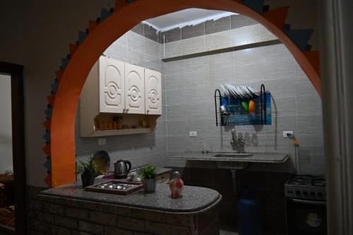 a model of a kitchen with an arch over a counter at شقة رويال سويت in Abu Simbel