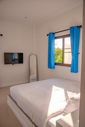 a bedroom with a bed with blue curtains and a window at Modern Nature Retreat in Ko Phangan
