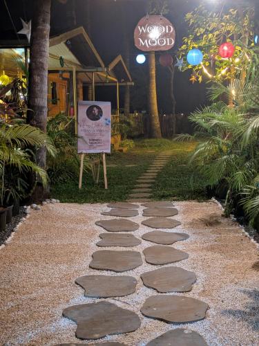 a stone walkway with a sign in front of a house at WOODMOOD Cottages in Chapora