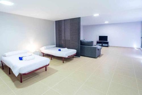 a hospital room with two beds and a couch at Villa Los Dragos Golf by Infinity Summer in San Bartolomé