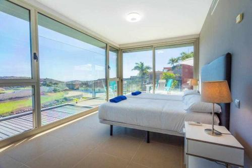 a bedroom with a bed and a large window at Villa Los Dragos Golf by Infinity Summer in San Bartolomé