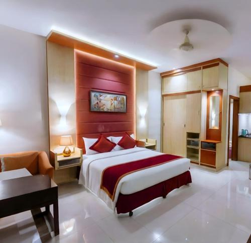 a hotel room with a large bed and a desk at Green Goose by Lakeshore Dhaka in Dhaka