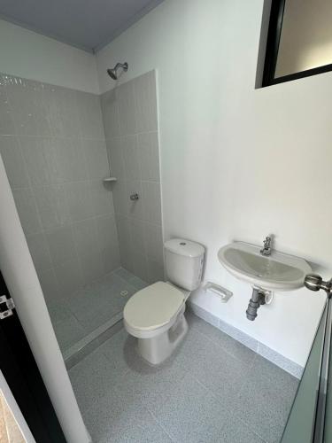 a bathroom with a toilet and a sink at Hotel Central Park Cartago in Cartago