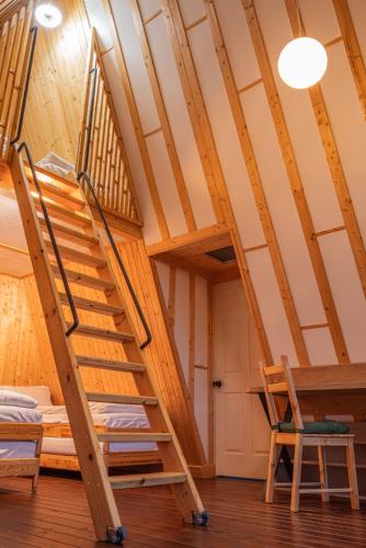 a room with a bunk bed and stairs in a attic at Lala Camp in Vama Buzăului