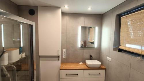 a bathroom with a sink and a mirror at Szumny Apartment 13a in Brzozówka