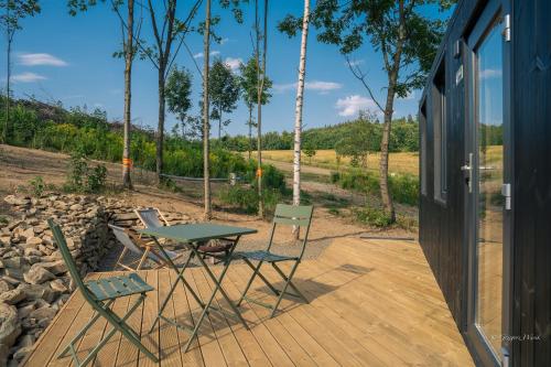a table and chairs sitting on a wooden deck at OtuliLas - Tiny House in Komarno