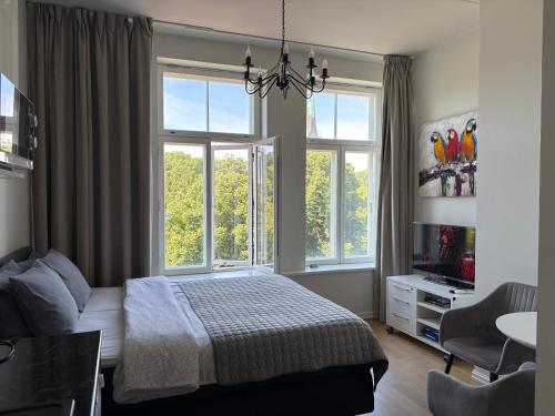 a bedroom with a bed and two windows at Orange Apartments Mere in Tallinn
