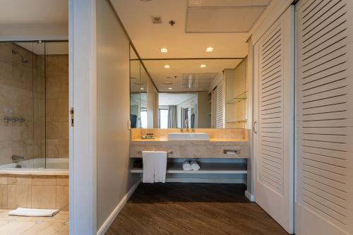a bathroom with a tub and a sink at Hotel Deville Prime Porto Alegre in Porto Alegre