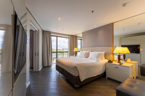a hotel room with a bed and a large window at Hotel Deville Prime Porto Alegre in Porto Alegre
