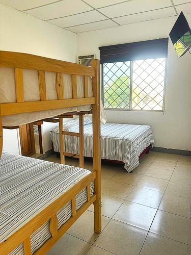 a bedroom with two bunk beds and a window at Caracola, habitación privada de Flor de Lis Beach House in Playas