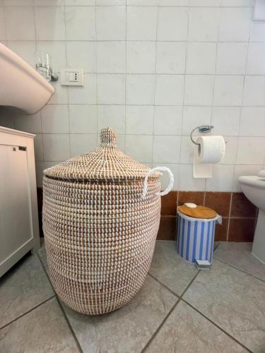 a bathroom with a large wicker trash can and a sink at La Terrazza sul Golfo in Golfo Aranci