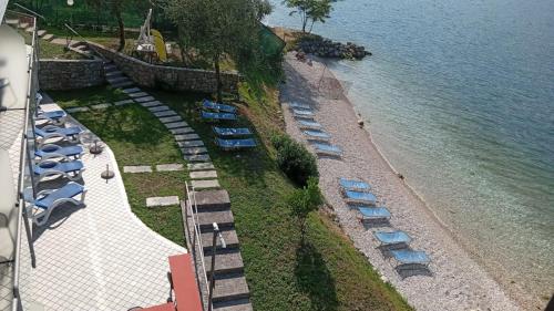 an overhead view of a beach with chairs and the water at Villa Monica in Malcesine