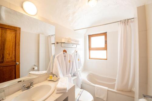 a white bathroom with a sink and a tub at San Agustin Internacional in Cusco