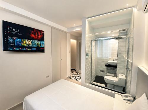 a small bathroom with a white bed and a toilet at Casa Patrones in Chiclayo