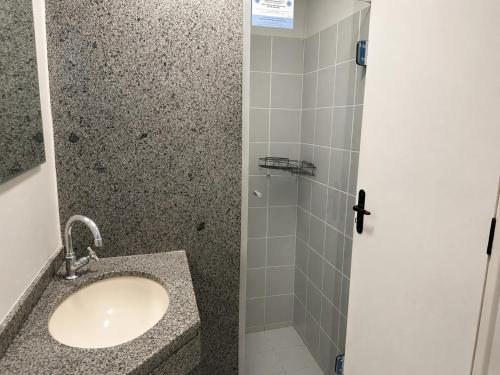 a bathroom with a sink and a shower at Hotel Alvorada Taguatinga by Bsb Inn in Taguatinga