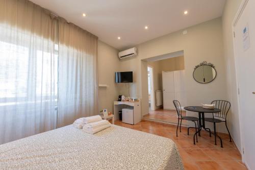a bedroom with a bed and a table with chairs at Artis Mare in Pozzuoli