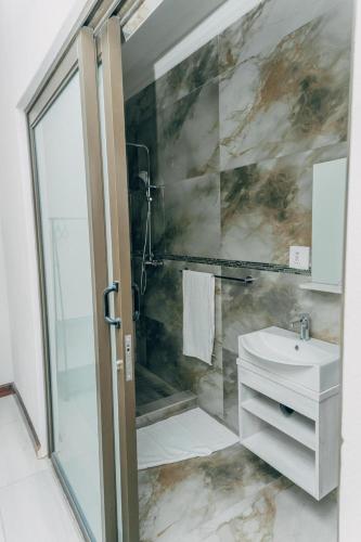 a bathroom with a glass shower and a sink at Beck Apartments - Kitwe in Kitwe