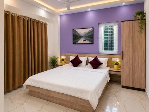 a bedroom with purple walls and a large bed at Eve Service apartment in Mysore