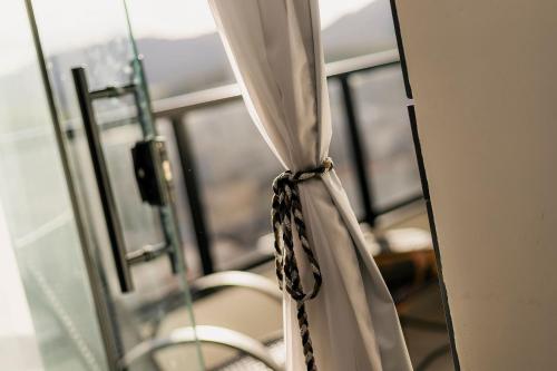 a curtain in a room with a window at Flats Diamond - Conforto, ed.novo e moderno localização impar in São Lourenço