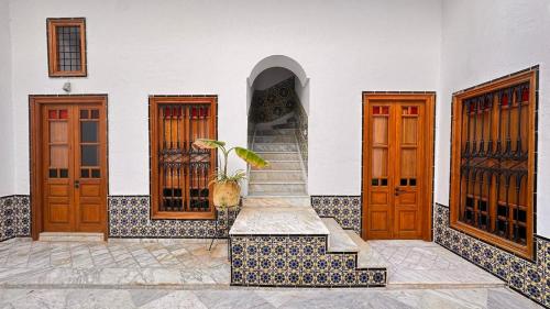 a house with three doors and a staircase in front at bayt el yemin in Kasbah