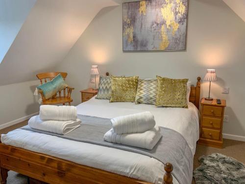 a bedroom with a large bed with two pillows at The Cottage in Salisbury