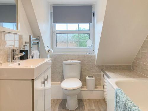 a bathroom with a toilet and a sink and a tub at The Cottage in Salisbury