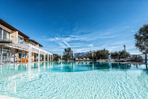 ein großer Pool in einem Hotel mit blauem Wasser in der Unterkunft La Chioma di Berenice Garda Residence in Toscolano-Maderno