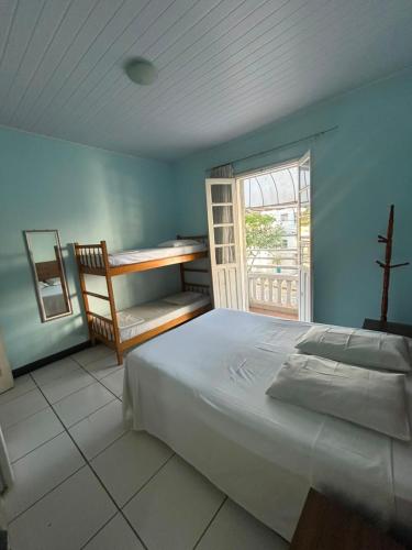 a bedroom with a bed and a desk and a window at Hotel Planalto in Poços de Caldas
