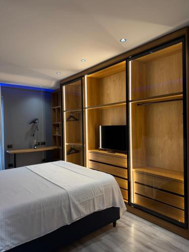 a bedroom with a bed and a flat screen tv at family-haven in Tirana