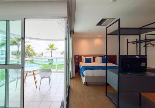 a bedroom with a bed and a balcony at Wyndham Rio Barra - Oficial in Rio de Janeiro