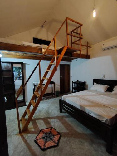 a bedroom with a wooden bunk bed with a ladder at Eco Palms in Pottuvil