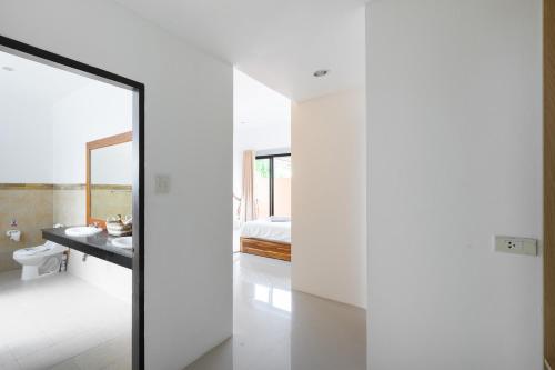 a white bathroom with a bed and a mirror at The Orange Villa Near Beach in Kamala Beach
