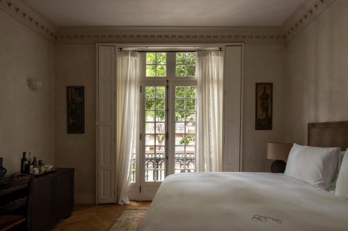 a bedroom with a large bed and a large window at El Cortés, Member of Relais & Châteaux in Mexico City