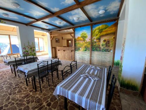 a room with tables and chairs and a painting on the wall at Пентхаус РіОНі Трускавець in Truskavets