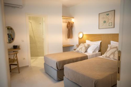 a hotel room with two beds and a bathroom at Vounara Houses in Artemonas