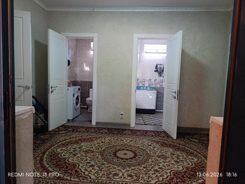 a bathroom with two open doors and a bathroom with a tub at Baktygul in Karakol