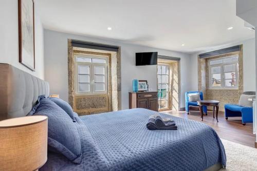 a bedroom with a blue bed with a blue blanket at Casa do Forno in Ponte da Barca