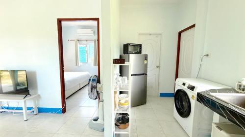a kitchen with a refrigerator and a washing machine at Temple Light in Ko Phangan