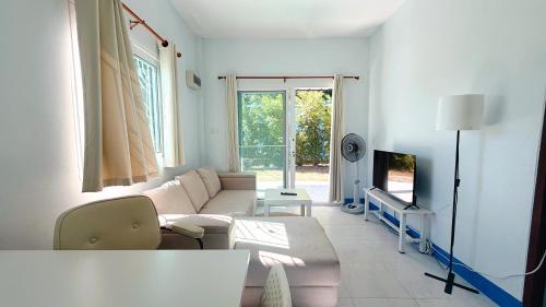 a living room with a couch and a tv at Temple Light in Ko Phangan