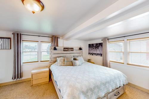 a bedroom with a large bed and two windows at Montego Bay - Ocean 13336 in Ocean City