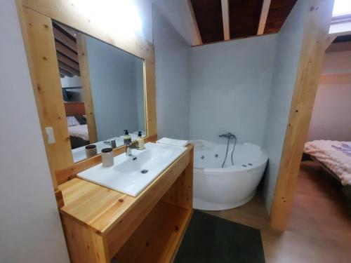 a bathroom with a white sink and a tub at SEL apartamentos rurales in Sel de la Carrera