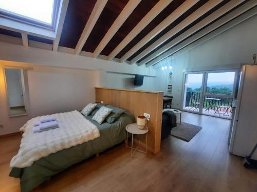 a bedroom with a large bed and a balcony at SEL apartamentos rurales in Sel de la Carrera