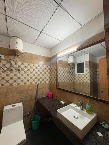 a bathroom with a sink and a toilet and a mirror at Zen Studio Paramount in Greater Noida