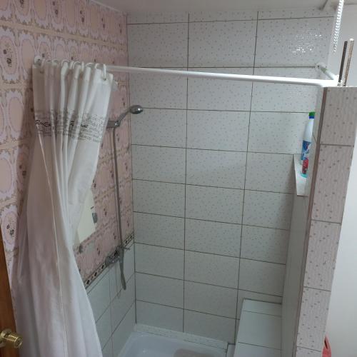 a bathroom with a shower with a shower curtain at Guesthouse Playa Chinchorro in Arica