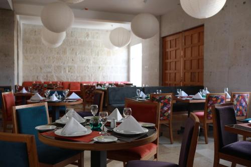 a dining room with tables and chairs and lights at San Agustin Posada del Monasterio in Arequipa