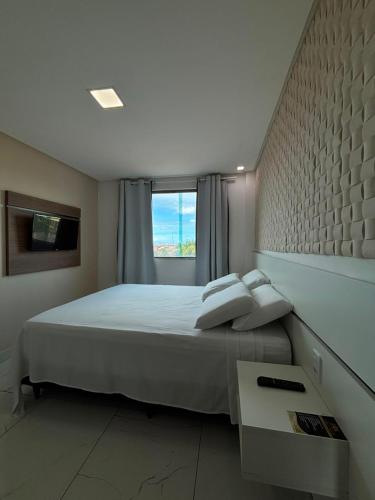 a bedroom with a large white bed with a window at Goiana Palace Hotel - Perto da JEEP, KLABIN, HEMOBRÁS, VIVIX in Goiana