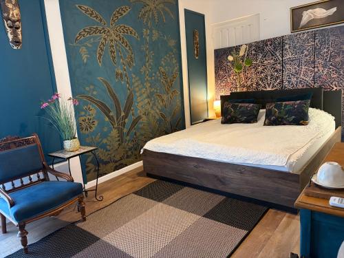 a bedroom with a bed and a chair at Villa Lavanda Vendégház & Spa in Gyulakeszi