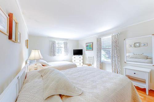a white bedroom with two beds and a window at The Sea Captain's Sanctuary in Ocean City